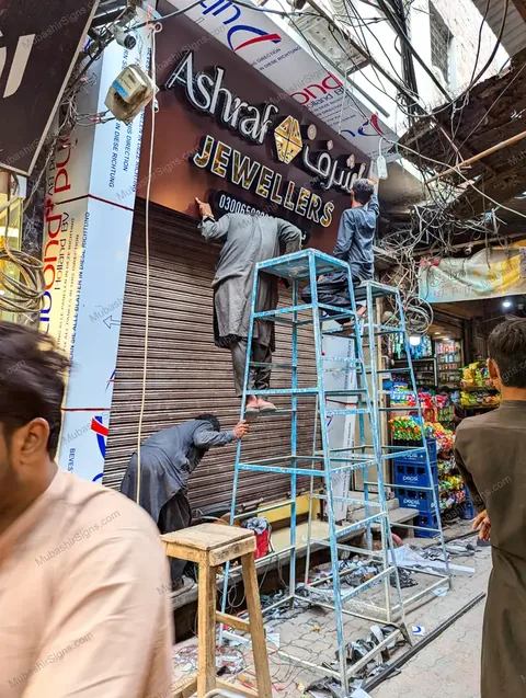 Mubashir team fitting the Ashraf Jewellers sign and fascia in Kasur during installation